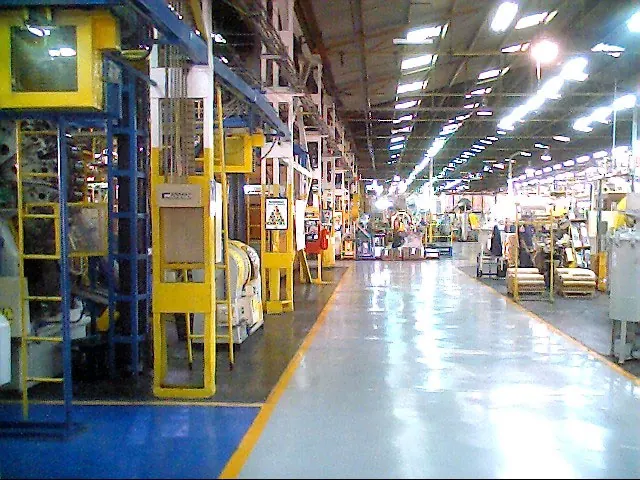 Piso industrial terminado con demarcación amarilla en planta metalúrgica